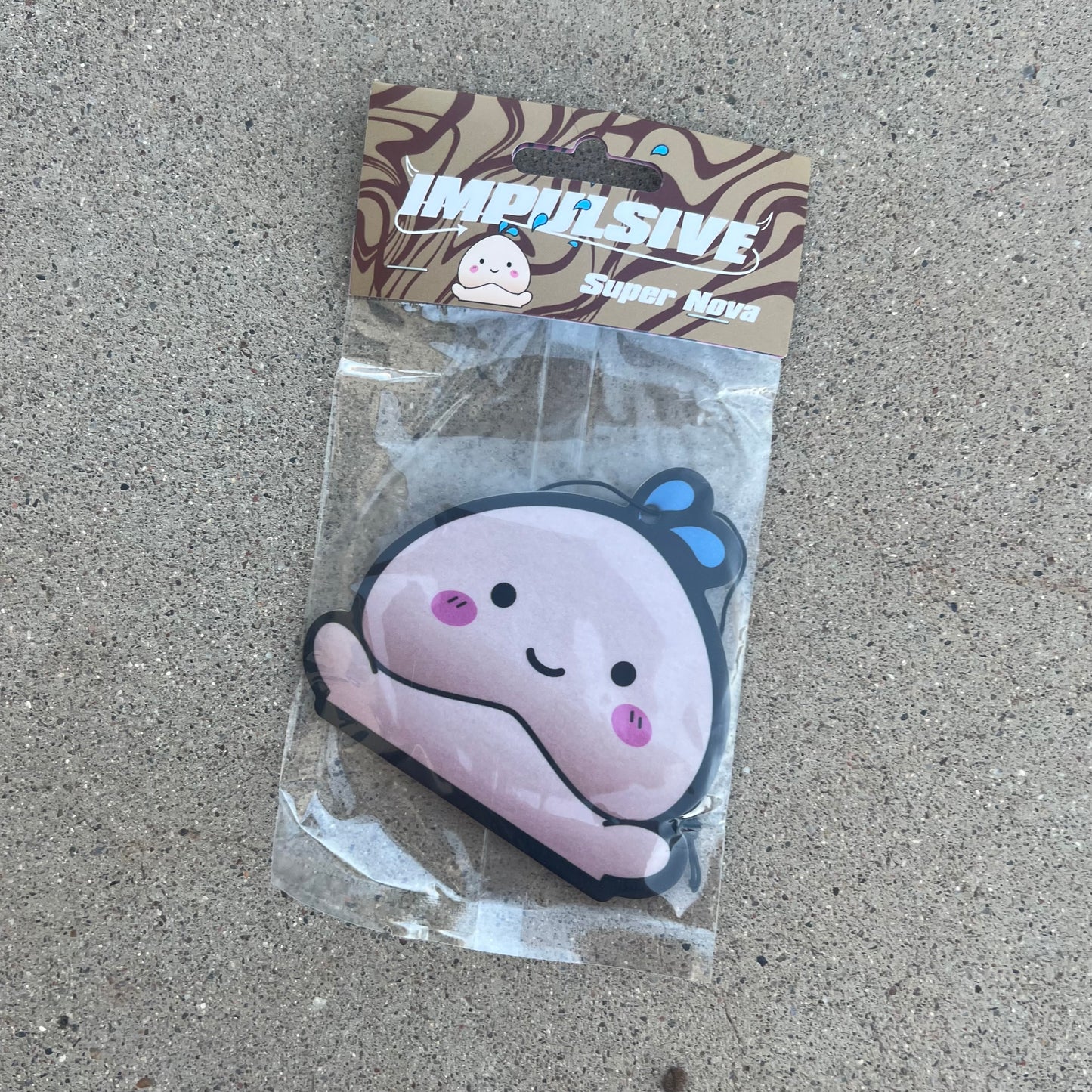 Japanese Cartoon Happy PeePee pp Penis Air freshener. Light Skin color super nova scent hanging from black string. brown swirl background with impulsive logo and water design dripping with super nova label cardboard head card packaging.