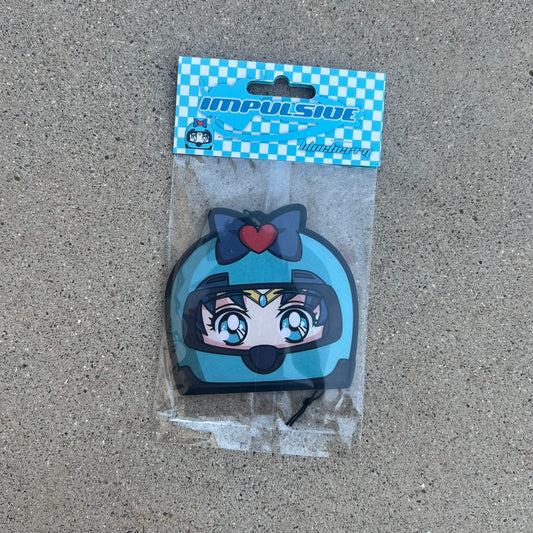 Sailor Moons friend sailor mercury air freshener hanging from black string. Wearing blue helmet with blue bow and red heart on blue eyed blue hair japanese anime girl. Blue and white checkered background with blue y2k impulsive logo and blueberry scent label cardboard head card packaging.