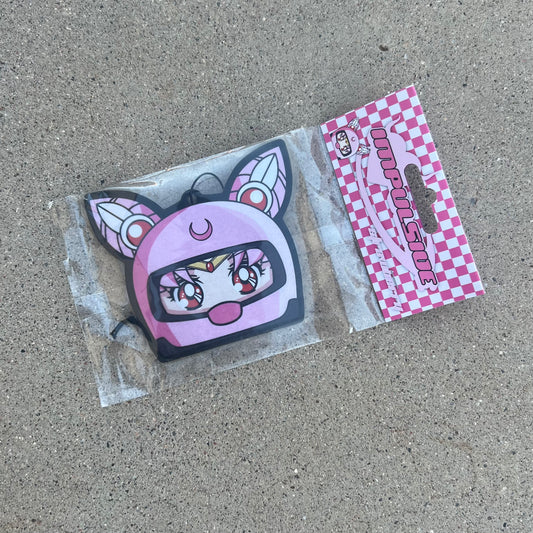 Chibi USA in pink helmet hanging from black string air freshener. Pink Checker cardboard packaging with pink y2k impulsive logo strawberry scent air freshener.