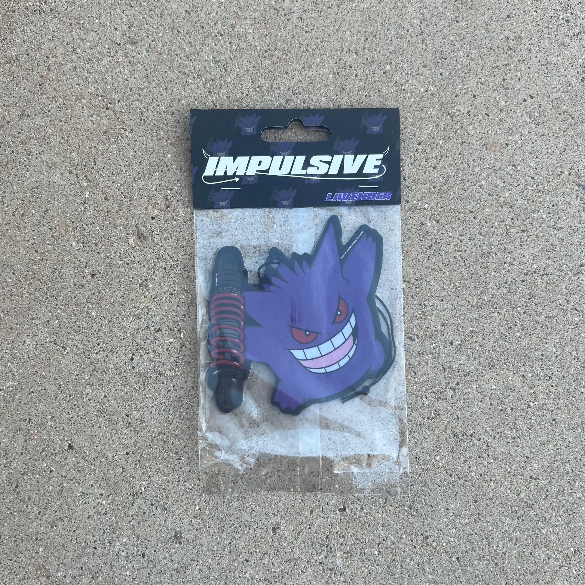 Pokemon Gengar Purple Monster holding Coilover car suspension hanging from black string air freshener. Impulsive LLC logo cardboard head card packaging. Lavender Scent air freshener