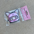 Chibi USA in pink helmet hanging from black string air freshener. Pink Checker cardboard packaging with pink y2k impulsive logo strawberry scent air freshener.