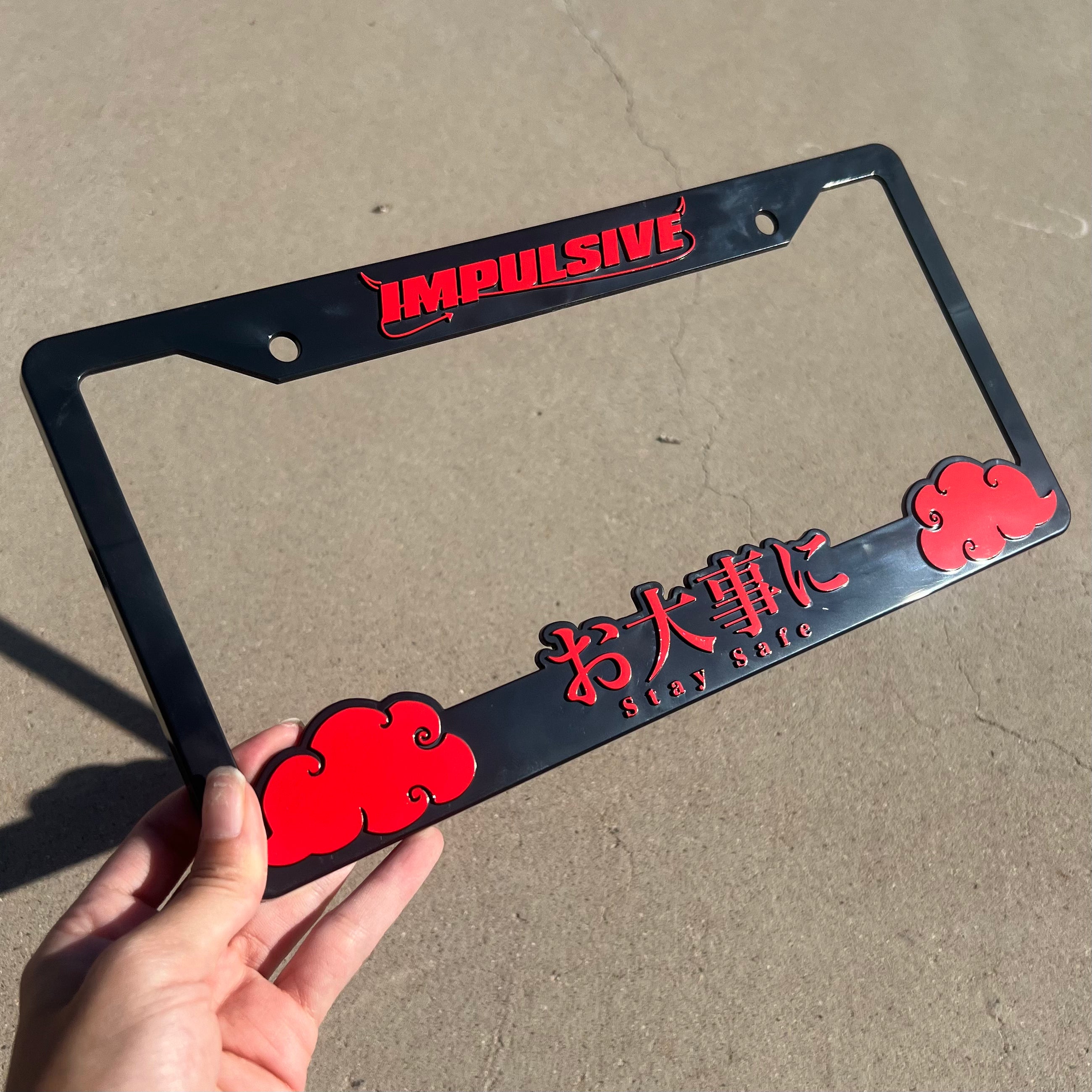 Japanese anime inspired plastic custom License Plate Frame. Top has Impulsive logo and the bottom has japanese characters and english translated to stay safe surrounding with japanese clouds. Asian inspired. Black Frame with Red lettering.
