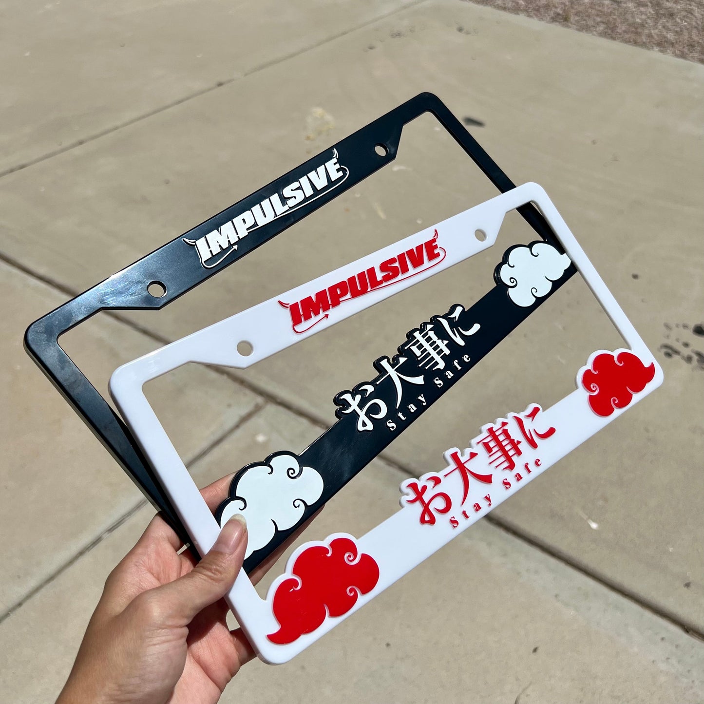 Japanese anime inspired plastic custom License Plate Frame. Top has Impulsive logo and the bottom has japanese characters and english translated to stay safe surrounding with japanese clouds. Asian inspired. White Frame with Red lettering.