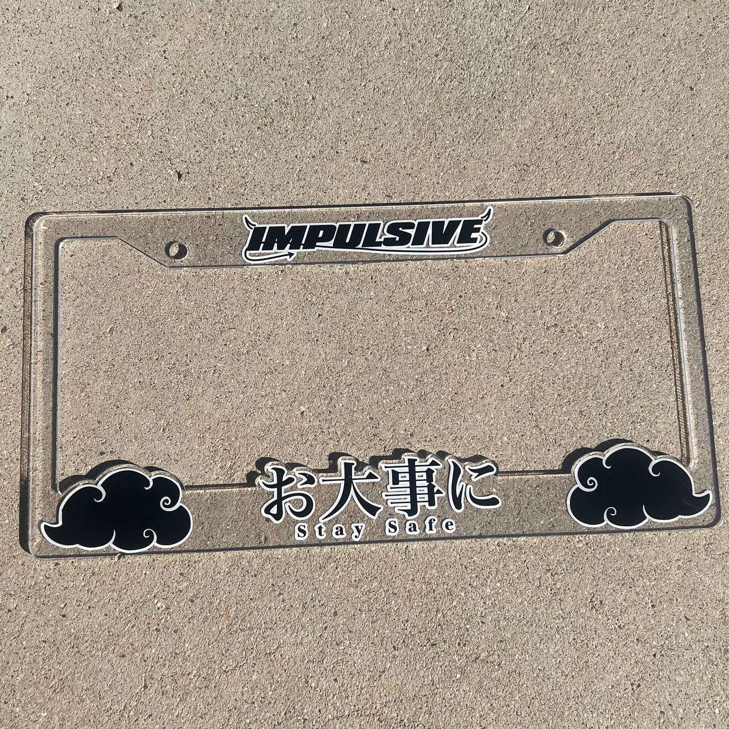 Japanese anime inspired plastic custom License Plate Frame. Top has Impulsive logo and the bottom has japanese characters and english translated to stay safe surrounding with japanese clouds. Asian inspired. Clear Acrylic cut Frame with black and white lettering.