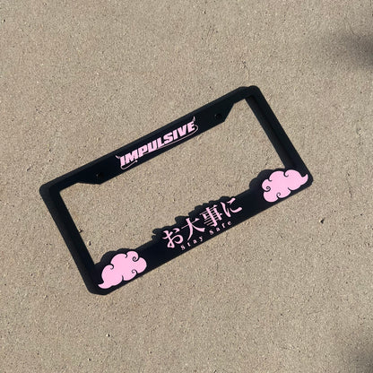 Japanese anime inspired plastic custom License Plate Frame. Top has Impulsive logo and the bottom has japanese characters and english translated to stay safe surrounding with japanese clouds. Asian inspired. Black Frame with Pink lettering.