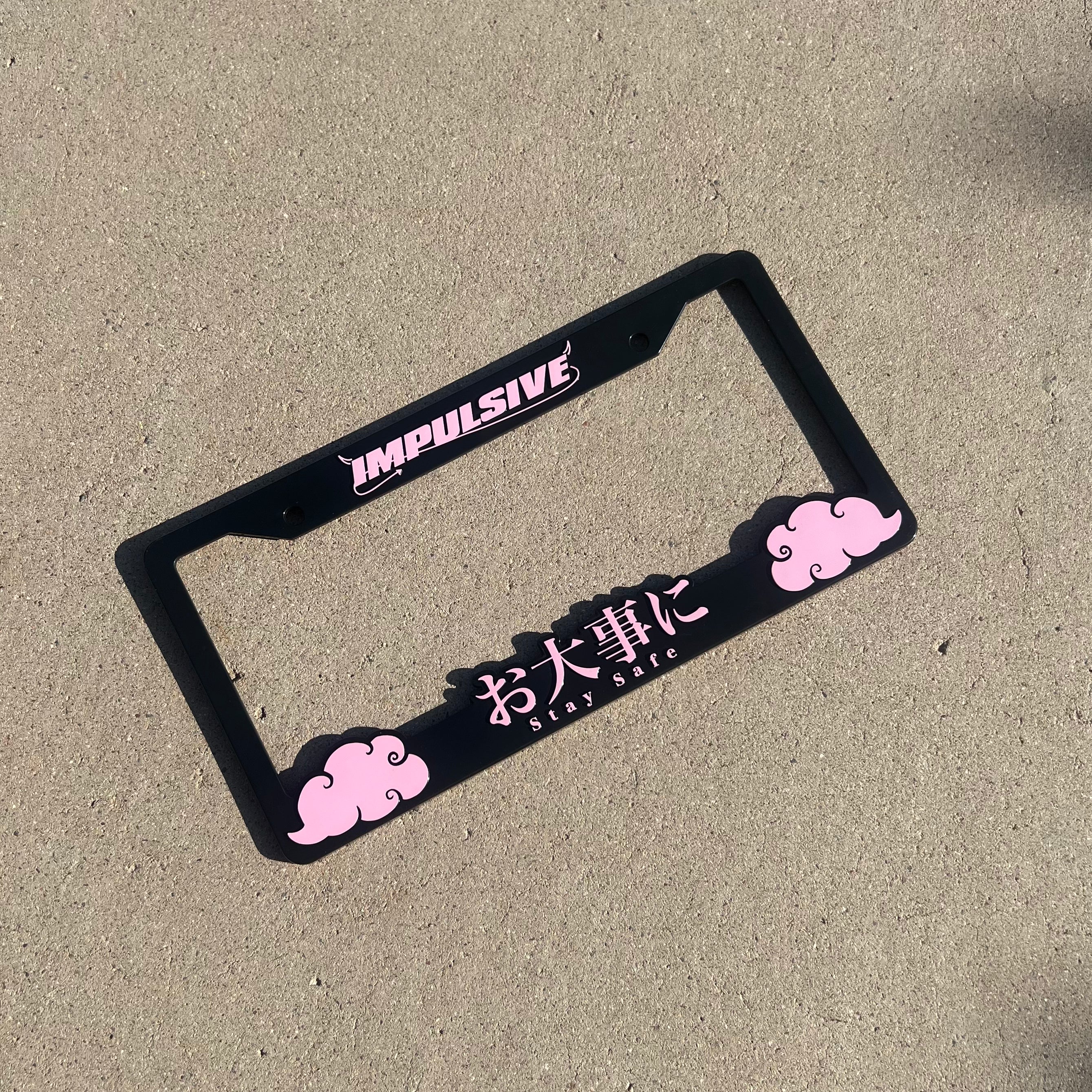 Japanese anime inspired plastic custom License Plate Frame. Top has Impulsive logo and the bottom has japanese characters and english translated to stay safe surrounding with japanese clouds. Asian inspired. Black Frame with Pink lettering.