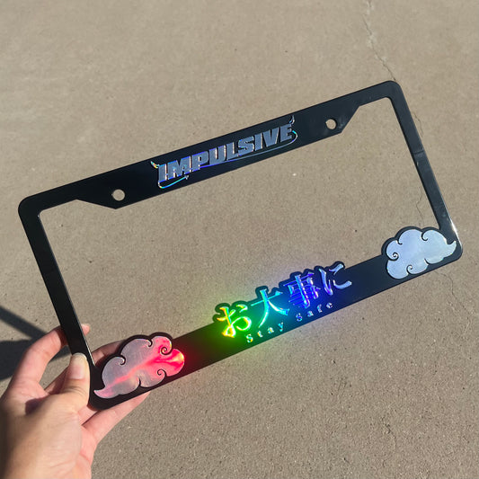 Japanese anime inspired plastic custom License Plate Frame. Top has Impulsive logo and the bottom has japanese characters and english translated to stay safe surrounding with japanese clouds. Asian inspired. Black Frame with rainbow oil slick chrome lettering.
