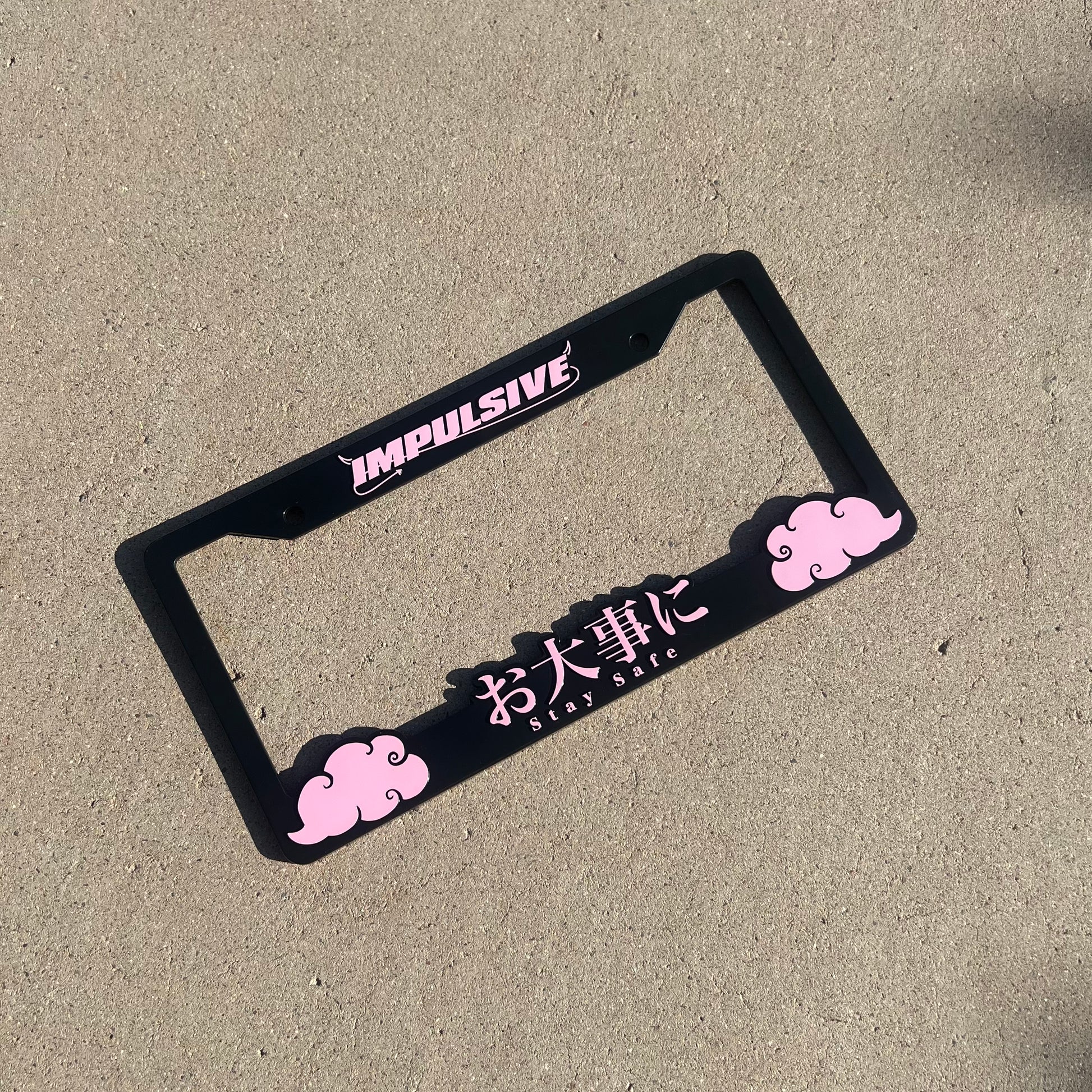 Japanese anime inspired plastic custom License Plate Frame. Top has Impulsive logo and the bottom has japanese characters and english translated to stay safe surrounding with japanese clouds. Asian inspired. Black Frame with pink lettering.