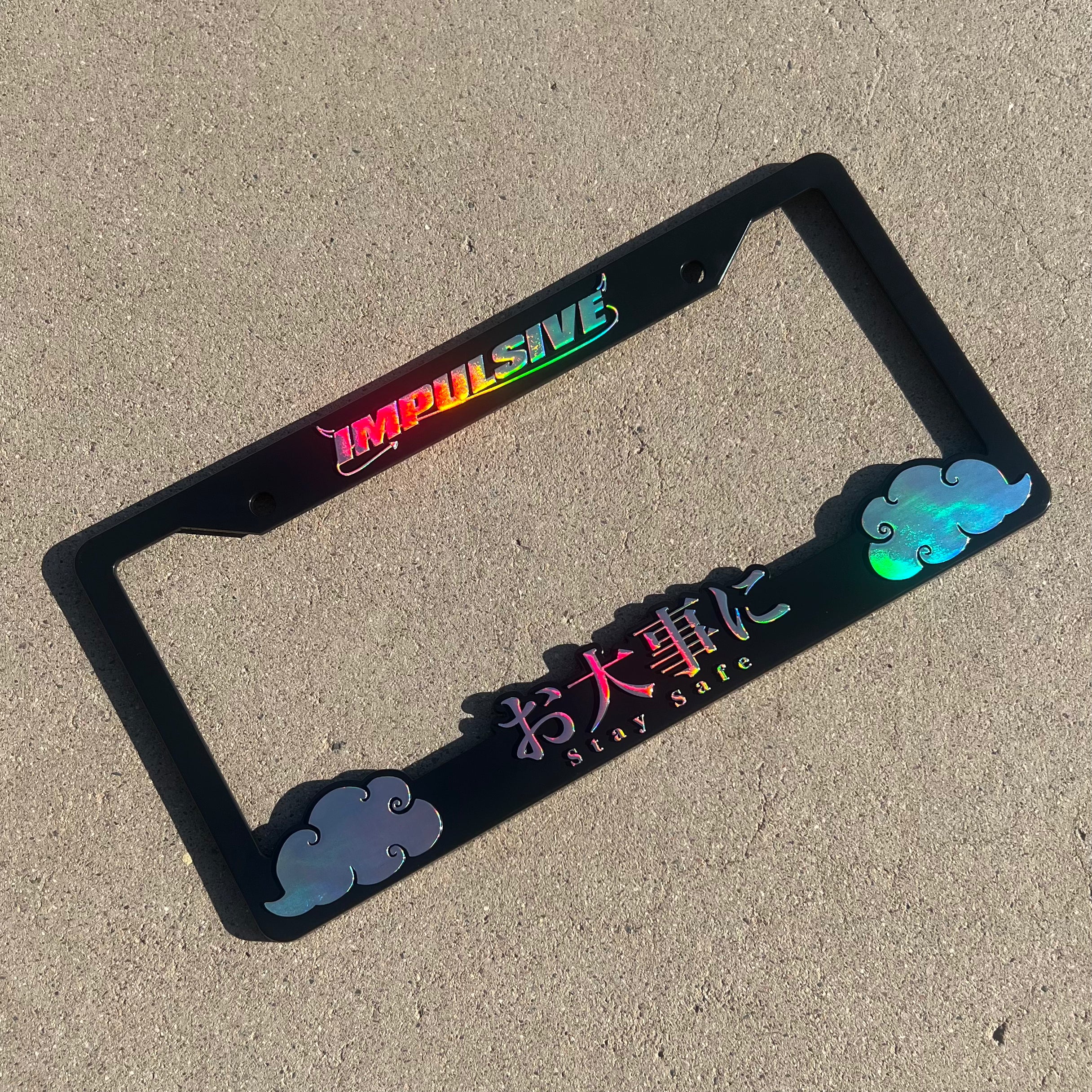 Japanese anime inspired plastic custom License Plate Frame. Top has Impulsive logo and the bottom has japanese characters and english translated to stay safe surrounding with japanese clouds. Asian inspired. Black Frame with rainbow oil slick chrome lettering.
