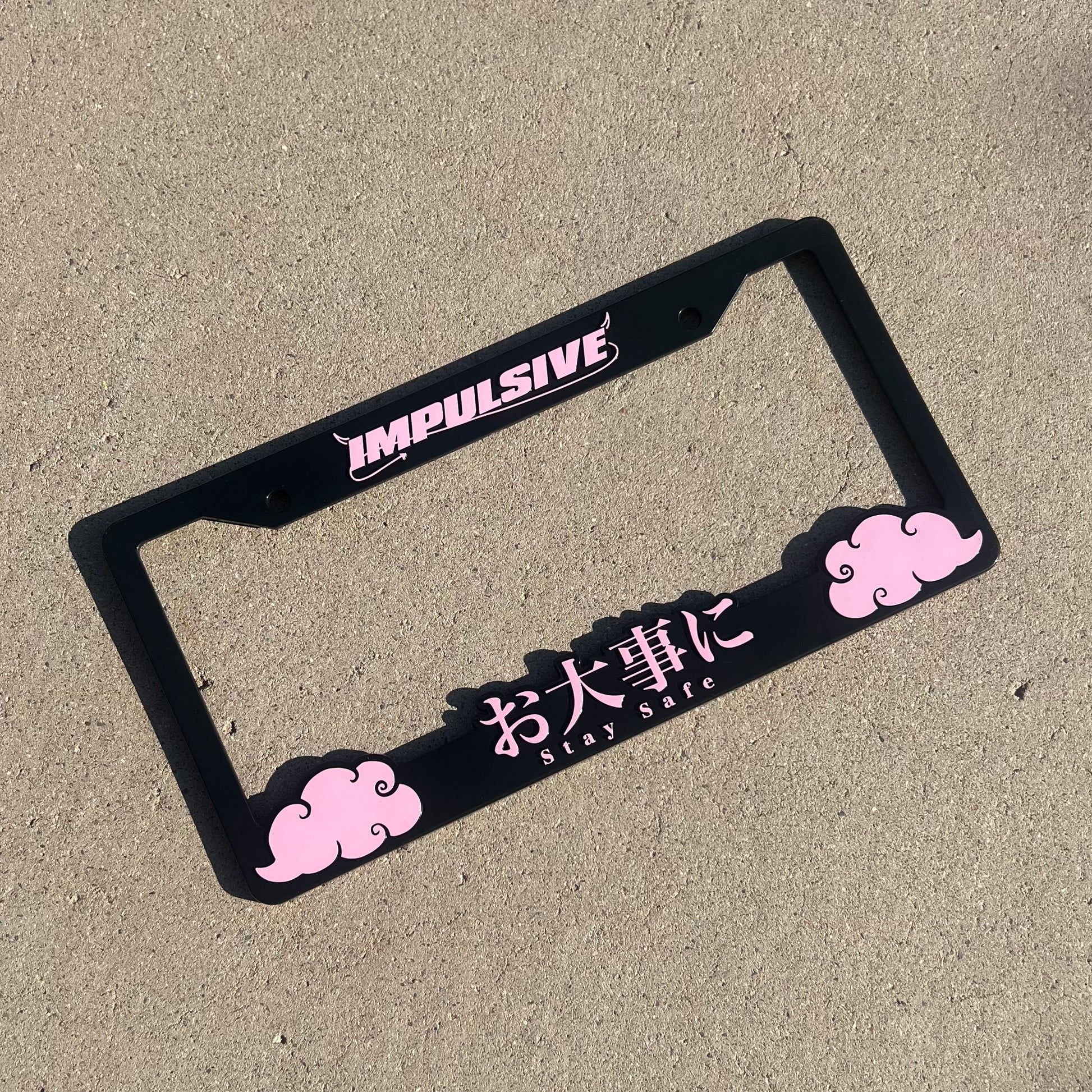 Japanese anime inspired plastic custom License Plate Frame. Top has Impulsive logo and the bottom has japanese characters and english translated to stay safe surrounding with japanese clouds. Asian inspired. Black Frame with Pink lettering.
