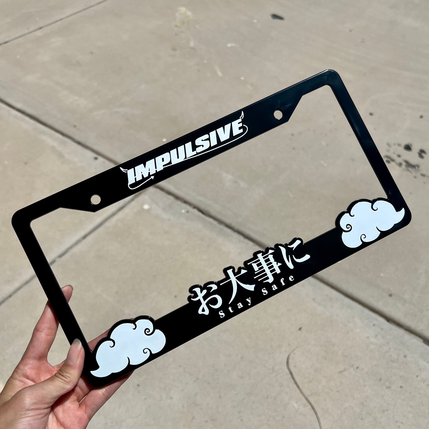 Japanese anime inspired plastic custom License Plate Frame. Top has Impulsive logo and the bottom has japanese characters and english translated to stay safe surrounding with japanese clouds. Asian inspired. Black Frame with white lettering.