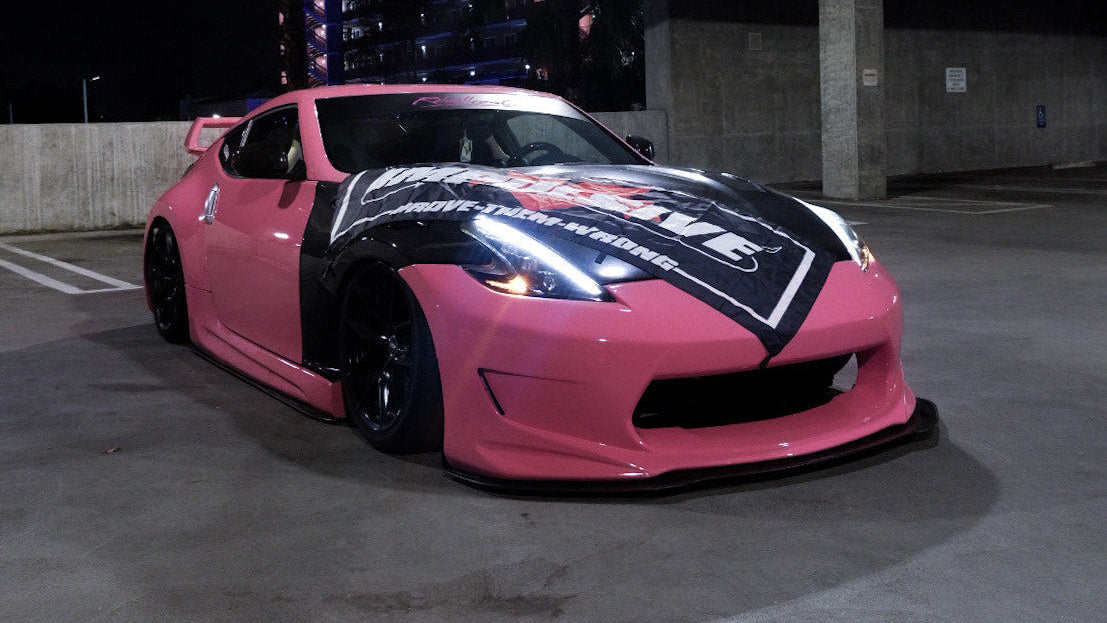 Pink sports car with black and white design in a parking garage