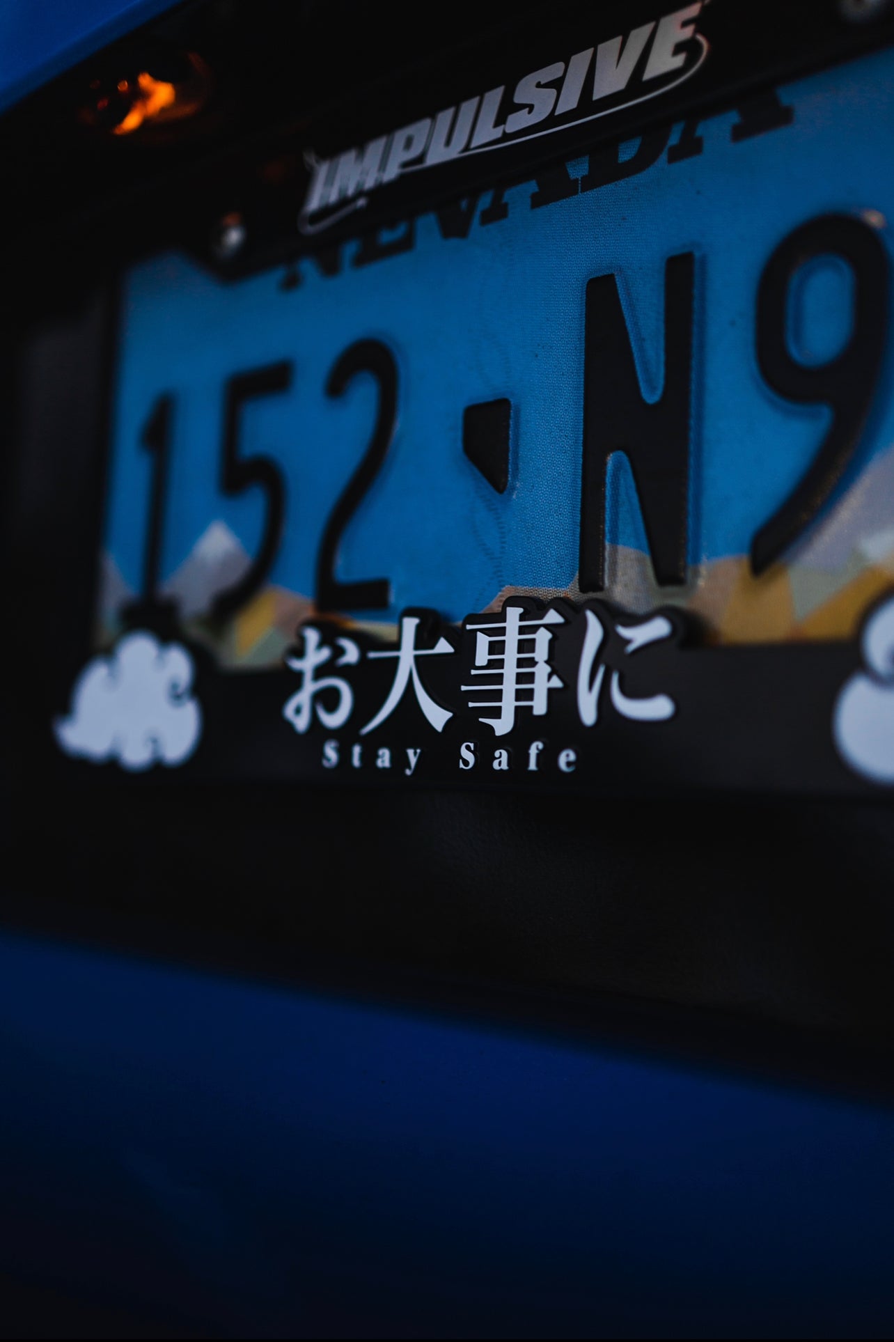 Japanese anime inspired plastic custom License Plate Frame. Top has Impulsive logo and the bottom has japanese characters and english translated to stay safe surrounding with japanese clouds. Asian inspired. Black Frame with white lettering.