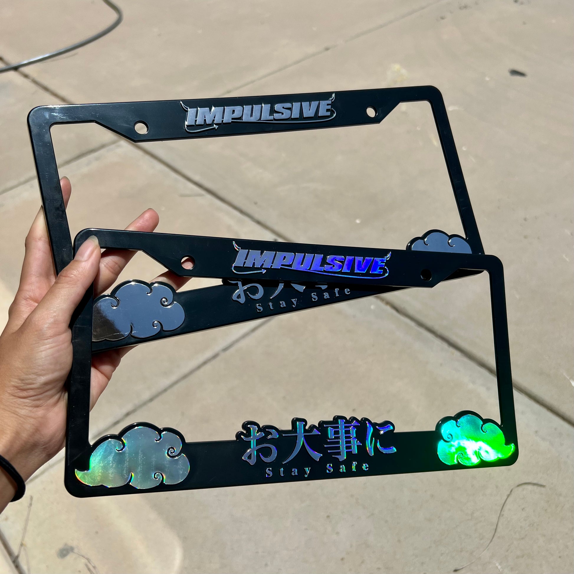 Japanese anime inspired plastic custom License Plate Frame. Top has Impulsive logo and the bottom has japanese characters and english translated to stay safe surrounding with japanese clouds. Asian inspired. Black Frame with chrome lettering and black frame with rainbow chrome oil slick lettering,